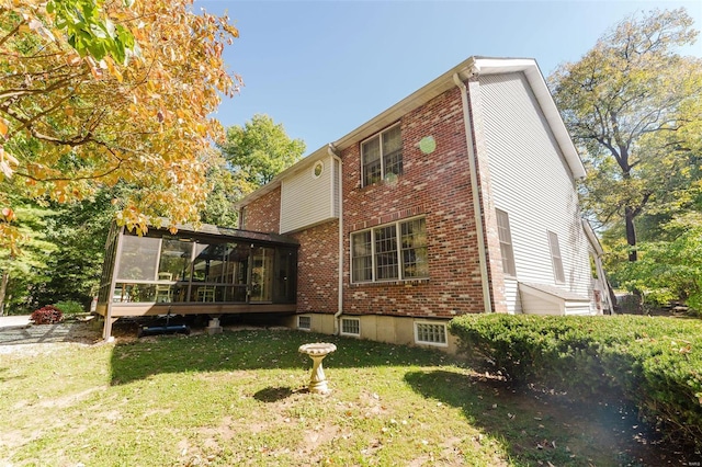 back of property featuring a sunroom and a lawn