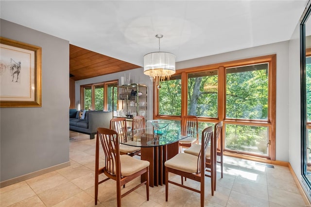 tiled dining area with plenty of natural light, wood ceiling, and an inviting chandelier