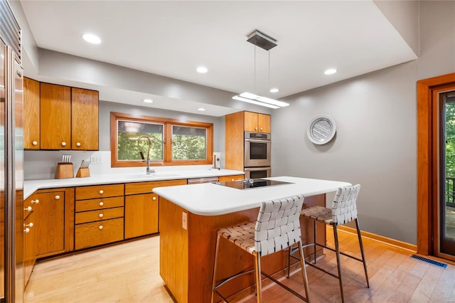 kitchen featuring plenty of natural light, decorative light fixtures, a center island, and stainless steel appliances