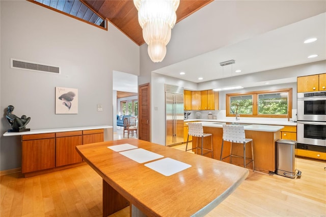 dining room with high vaulted ceiling, plenty of natural light, wood ceiling, and light hardwood / wood-style floors