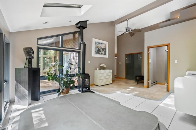 interior space featuring access to outside, vaulted ceiling with skylight, baseboard heating, and ceiling fan