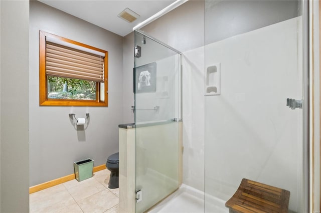 bathroom with a shower with door, tile patterned floors, and toilet