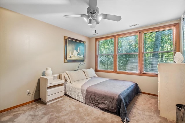 bedroom featuring light carpet, multiple windows, and ceiling fan