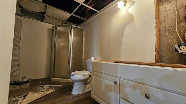 bathroom with hardwood / wood-style flooring, toilet, walk in shower, and vanity