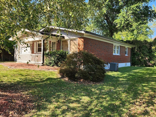 view of front facade with a porch, central AC unit, and a front yard