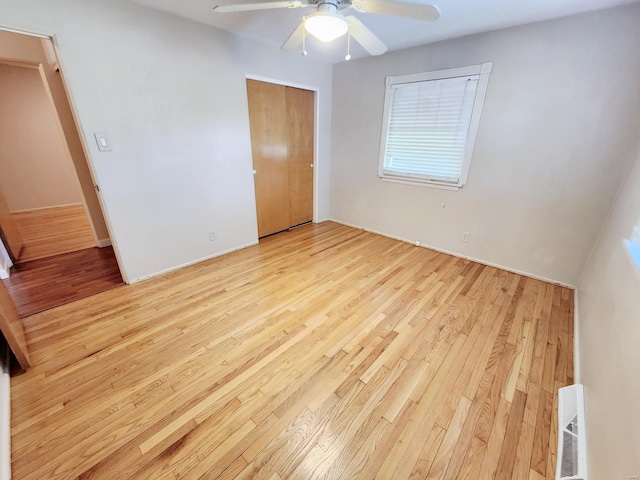 unfurnished bedroom featuring ceiling fan, light hardwood / wood-style flooring, and a closet