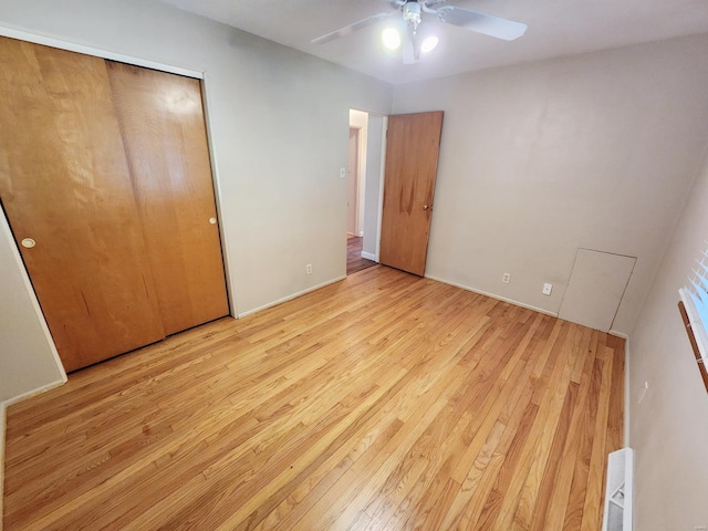 unfurnished bedroom featuring ceiling fan, a closet, and light hardwood / wood-style floors