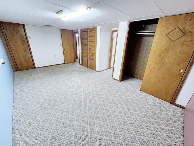 unfurnished bedroom with light carpet and multiple closets