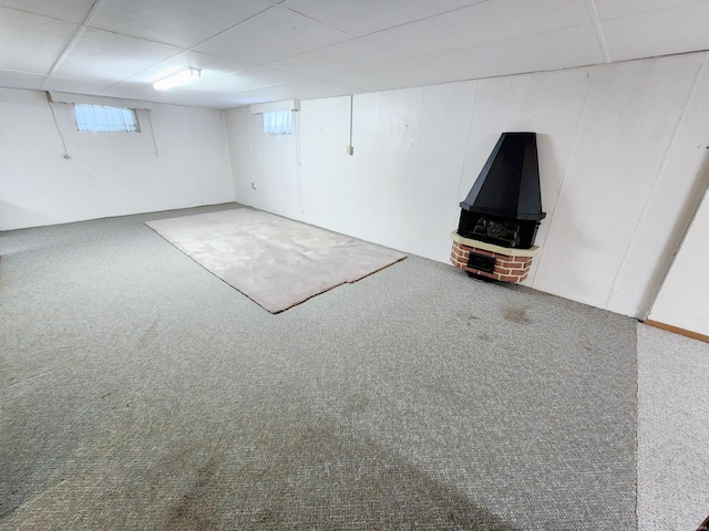 basement featuring carpet floors and a paneled ceiling