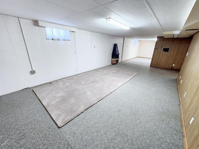 basement featuring wood walls and carpet