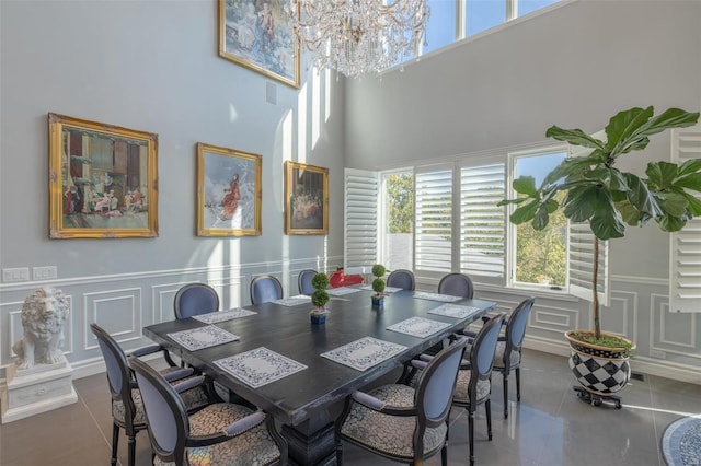 tiled dining space featuring a high ceiling and a notable chandelier