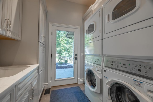 laundry area with washer and clothes dryer, light tile patterned floors, and cabinets