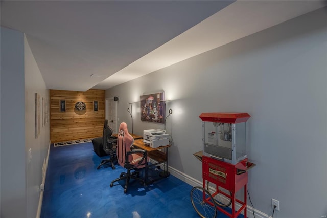 carpeted home office featuring wooden walls