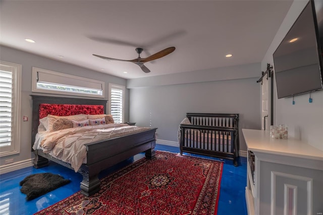 bedroom featuring a barn door and ceiling fan