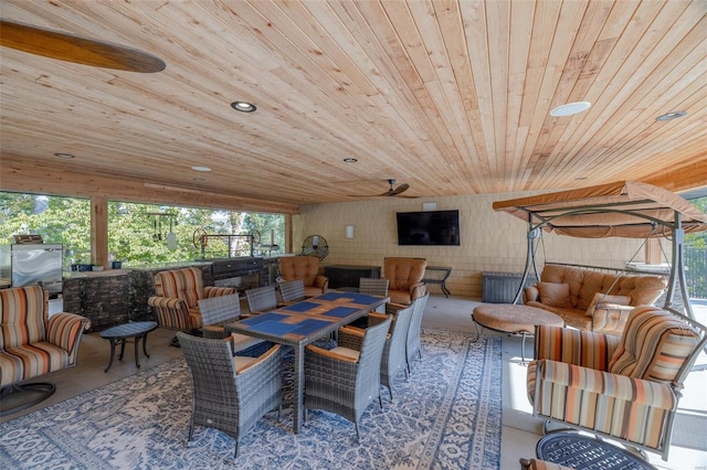 dining space with wooden ceiling, concrete floors, and ceiling fan