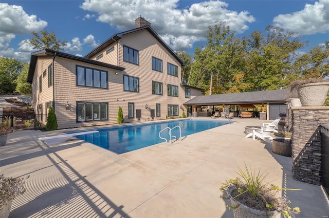 view of pool with a diving board and a patio area