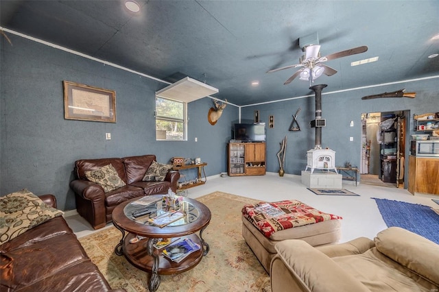 living room with ceiling fan and a wood stove