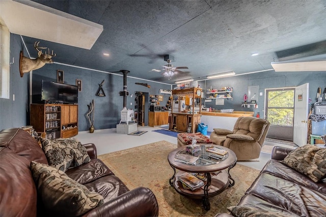 living room with ceiling fan, a textured ceiling, and concrete floors