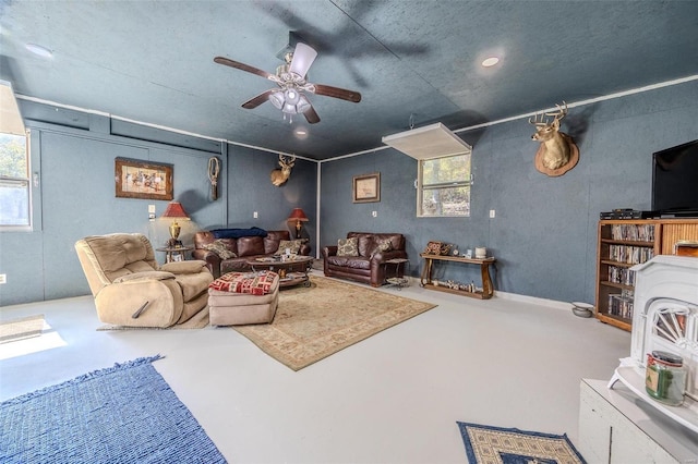 living room with concrete flooring, ceiling fan, and a healthy amount of sunlight