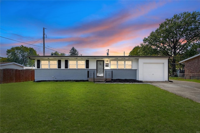 ranch-style house featuring a yard and a garage