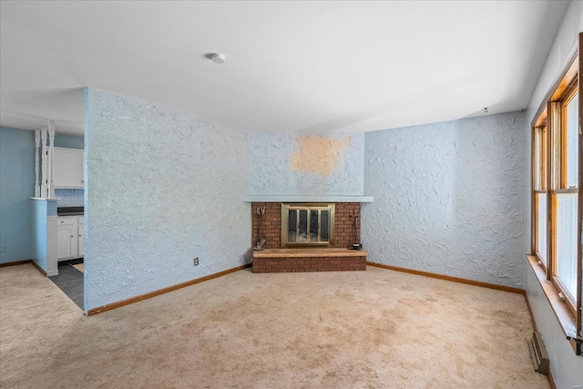 unfurnished living room featuring a fireplace and carpet flooring