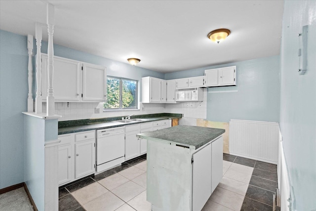 kitchen with light tile patterned flooring, a center island, white appliances, and white cabinetry