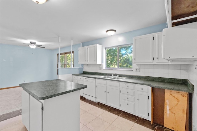 kitchen with decorative backsplash, white cabinetry, dishwasher, and sink