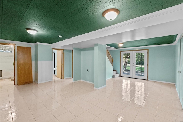 tiled spare room with ornamental molding and french doors