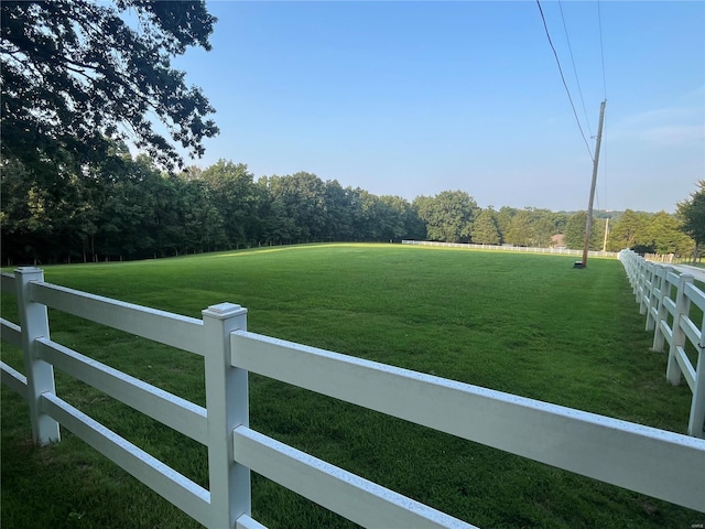 view of yard with view of golf course and fence