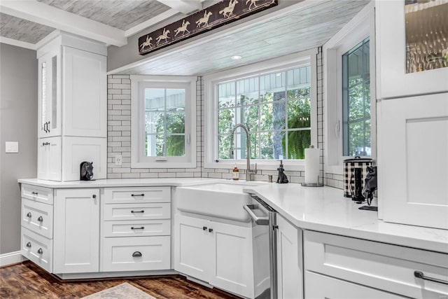 kitchen with beam ceiling, dark wood-type flooring, wood ceiling, white cabinetry, and a sink