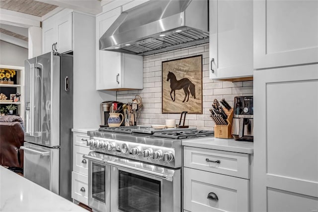 kitchen with white cabinets, range hood, light countertops, and premium appliances