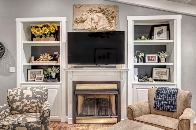 sitting room featuring light wood-style floors, a fireplace, and built in features