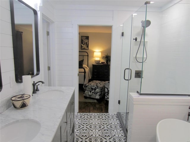 ensuite bathroom with a stall shower, a sink, ensuite bath, and double vanity