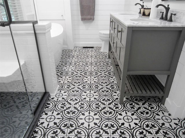 full bath with double vanity, tile patterned flooring, a sink, and a shower stall