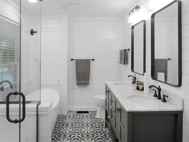 full bath featuring double vanity, toilet, a sink, and tile patterned floors