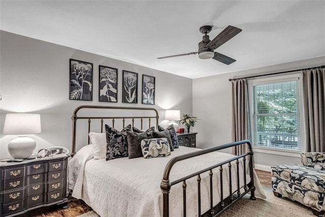 bedroom with ceiling fan, wood finished floors, and baseboards