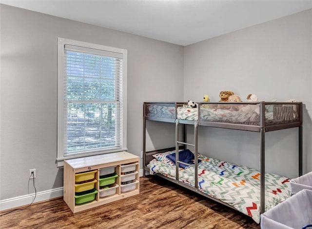 bedroom with baseboards and wood finished floors