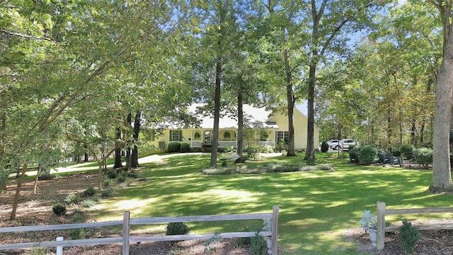 view of home's community with a yard and fence