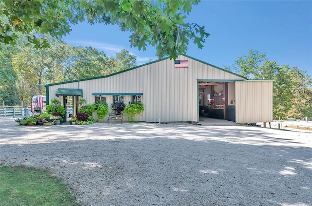 view of building exterior featuring a garage, driveway, and fence