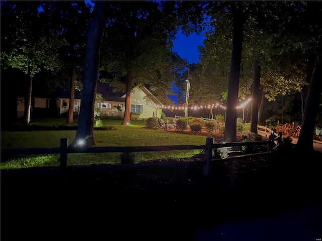 yard at twilight featuring fence