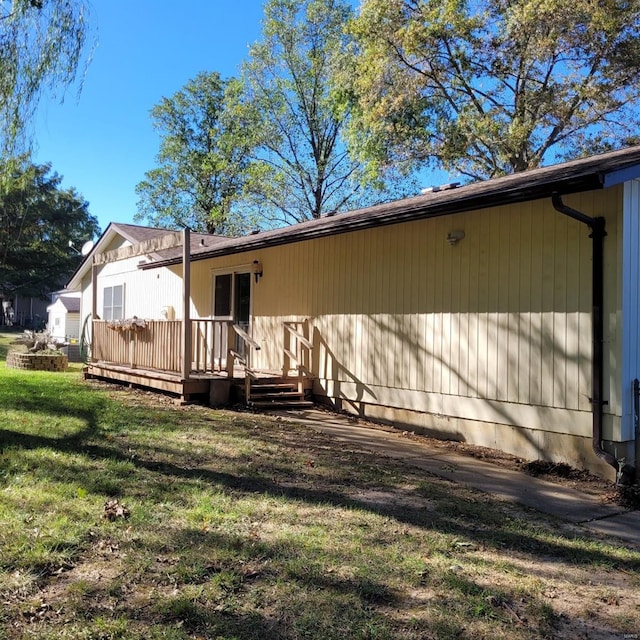 rear view of house featuring a yard and a deck