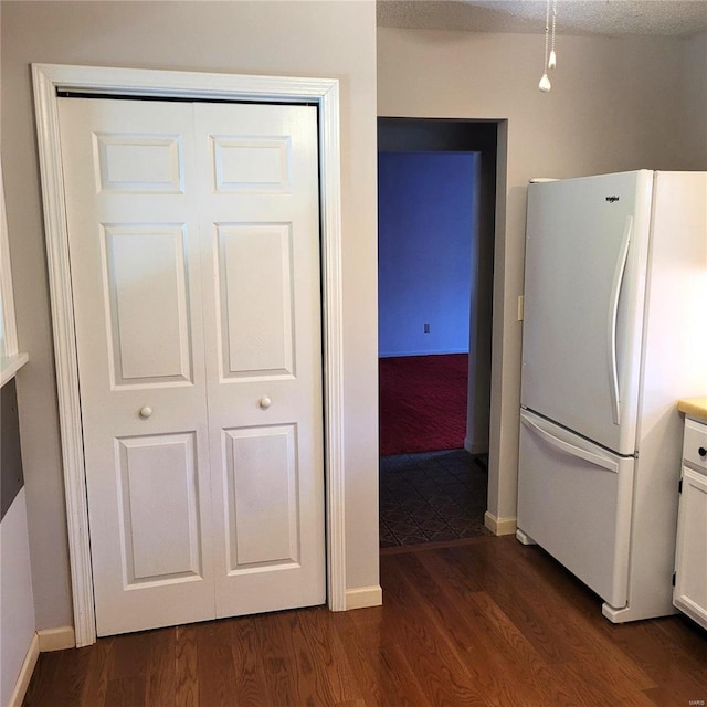 kitchen featuring white cabinets, a textured ceiling, white refrigerator, and dark hardwood / wood-style floors