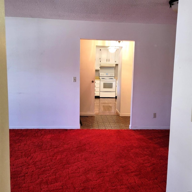 carpeted spare room featuring a textured ceiling