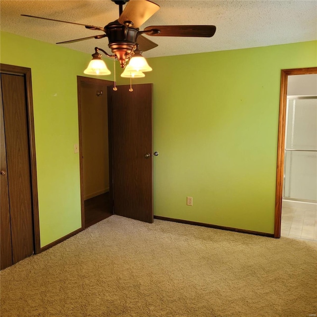 unfurnished bedroom with ceiling fan, a textured ceiling, and light carpet