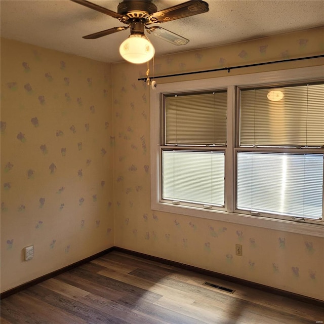 empty room with hardwood / wood-style floors, a textured ceiling, and ceiling fan