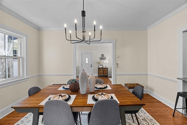 dining room featuring crown molding, a notable chandelier, and hardwood / wood-style flooring