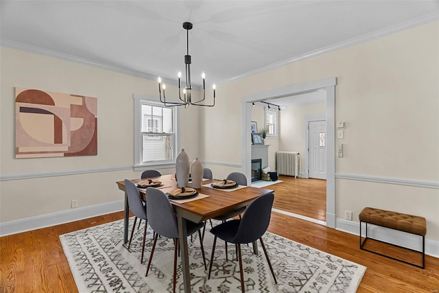 dining room featuring a chandelier, radiator heating unit, hardwood / wood-style flooring, and ornamental molding