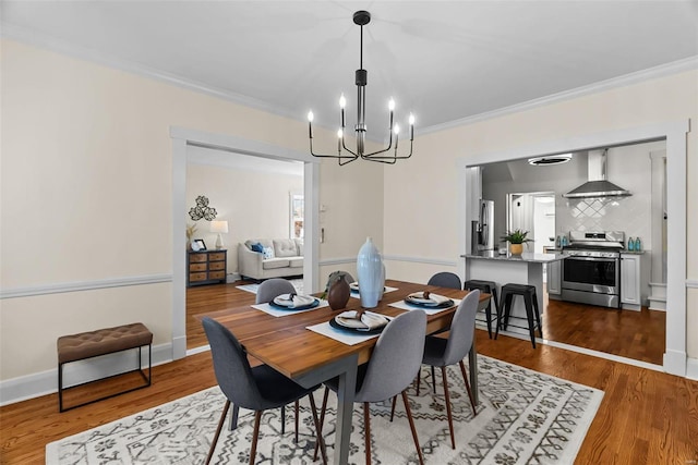 dining area featuring wood-type flooring, crown molding, and a chandelier