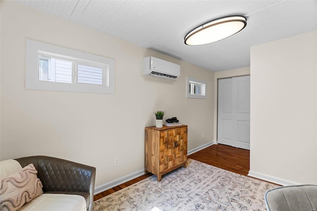 living area with a wall mounted air conditioner and light hardwood / wood-style floors