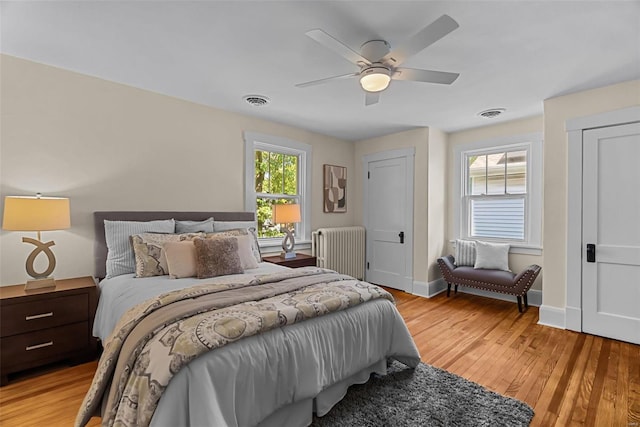 bedroom featuring radiator, ceiling fan, and light hardwood / wood-style floors